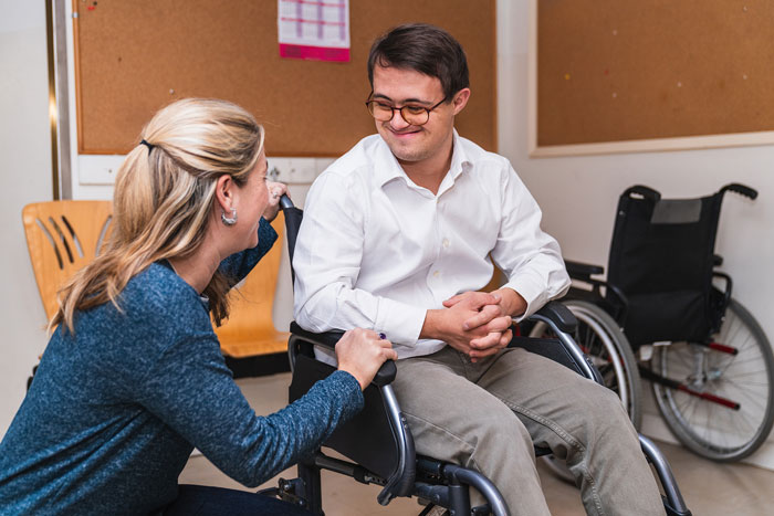 A man in a wheelchair engages in conversation with a woman