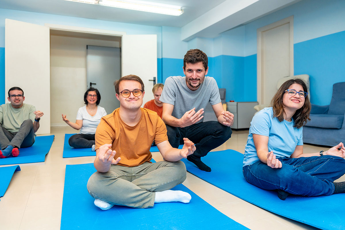 A diverse group of individuals seated on yoga mats